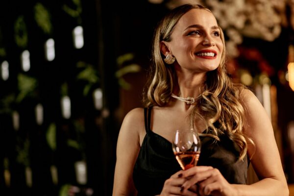 Charming,Woman,In,Evening,Attire,Holding,A,Wine,Glass,At